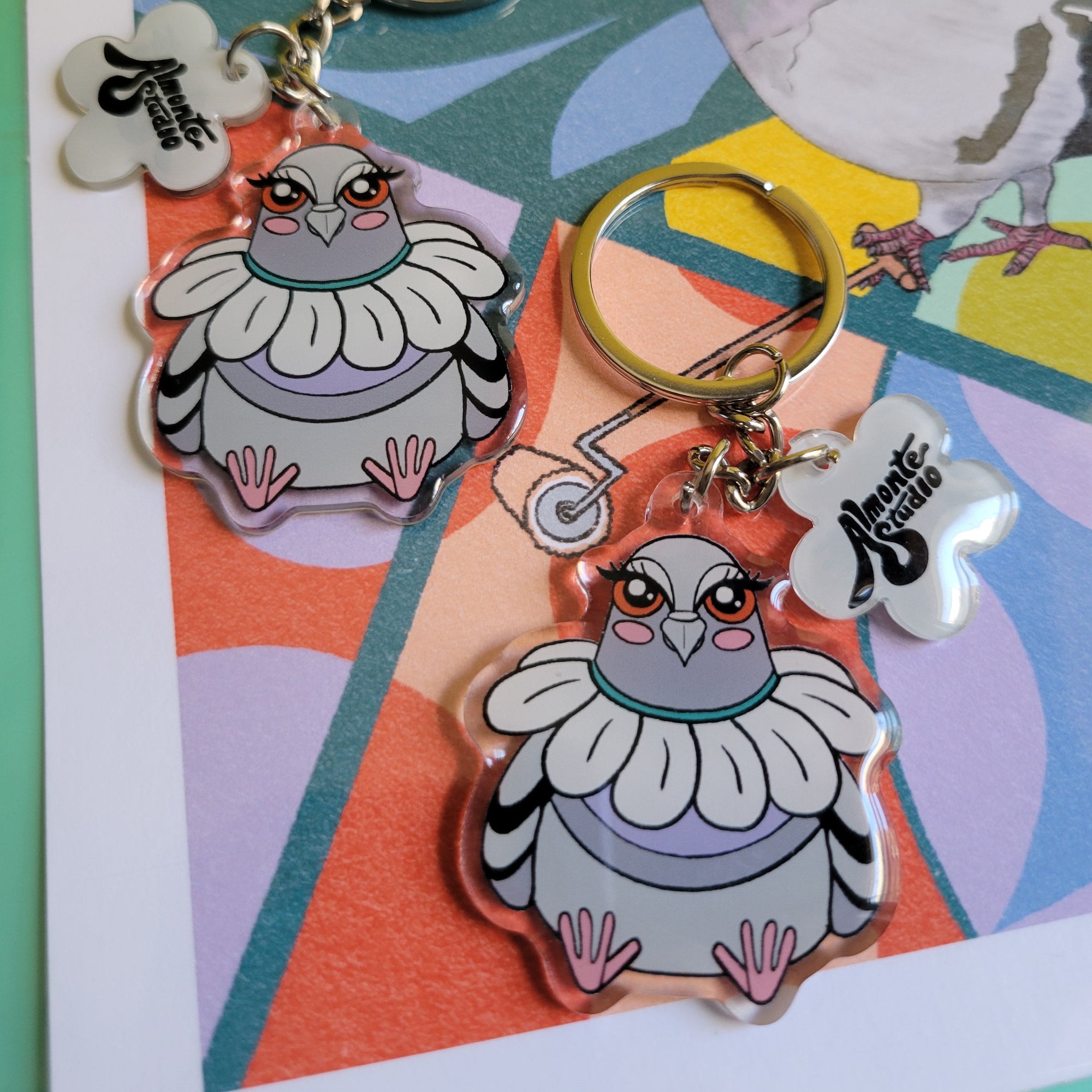 Keychains with cartoon pigeon character designs on a colorful background