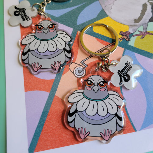 Keychains with cartoon pigeon character designs on a colorful background