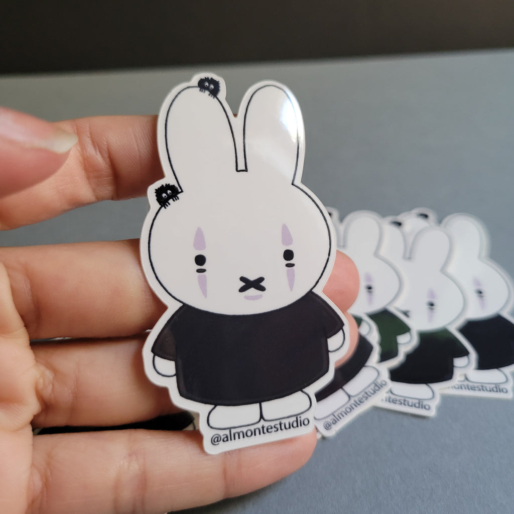 Hand holding a set of cartoon-style stickers with a neutral background